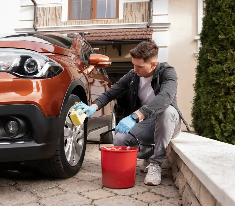 Lavage auto à domicile Saint-Ouen-les-Vignes : professionnel intervenant sur un véhicule